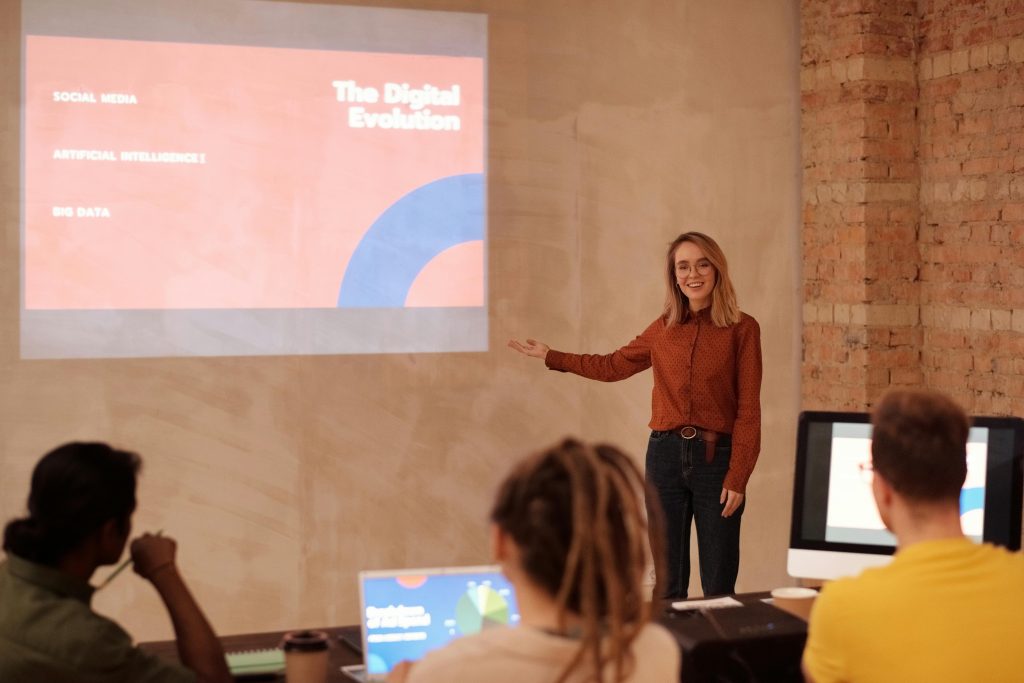 Young woman presenting on digital evolution concepts like AI and big data in a seminar.